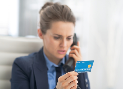 Photo of a woman doing a credit card transaction over the phone
